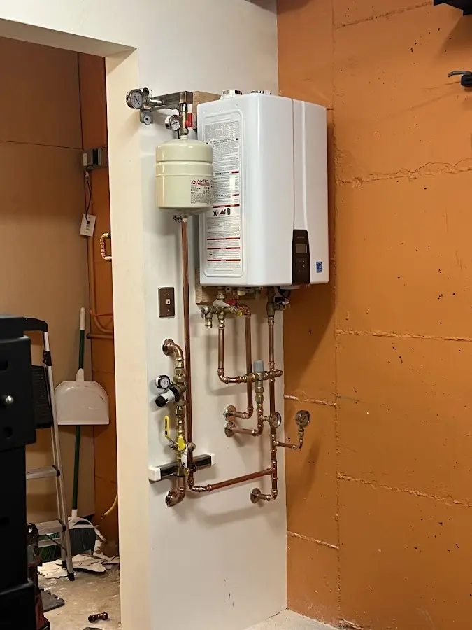 Plumbing technician inspecting water heater connections in North Chicago